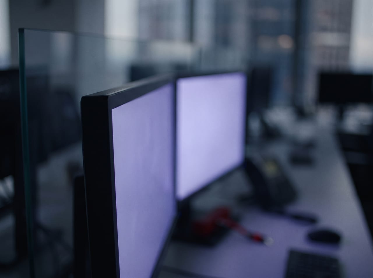 Borde de un monitor con reflejo violeta sobre vidrio